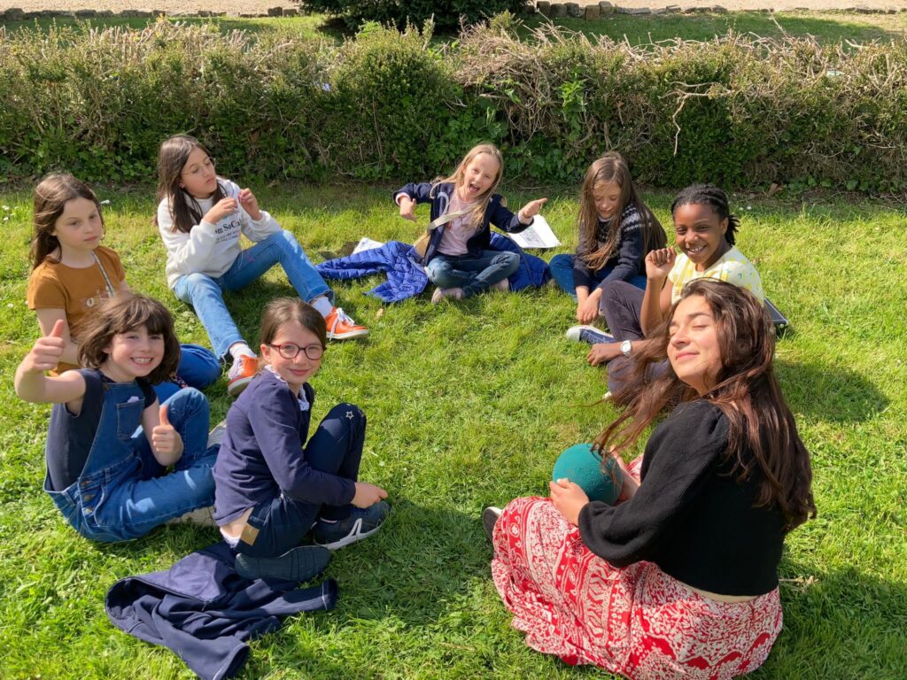 Un groupe d'enfants profite du soleil dans le parc du château.